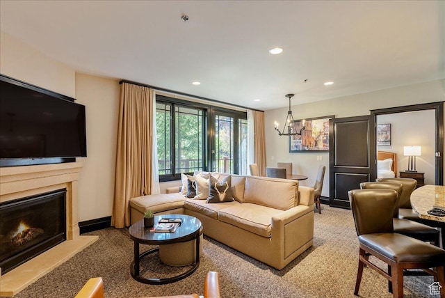carpeted living area with a chandelier, recessed lighting, a lit fireplace, and baseboards