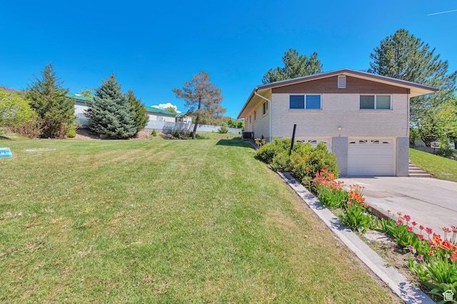 274 N 400 E, Hyde Park, UT 84318 - view of side of property with an attached garage, concrete driveway, a lawn, and central AC unit