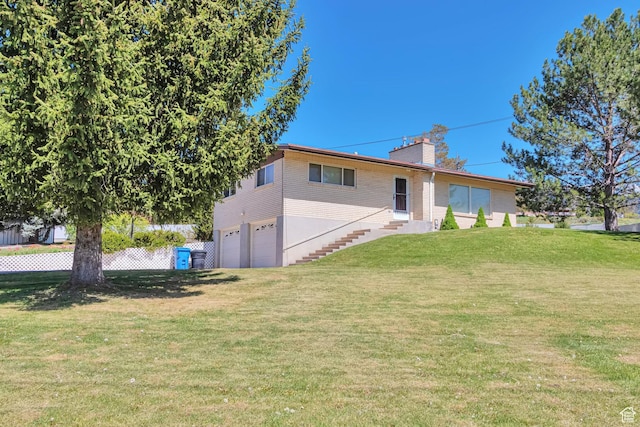 274 N 400 E, Hyde Park, UT 84318 - rear view of property featuring an attached garage, a chimney, and a lawn