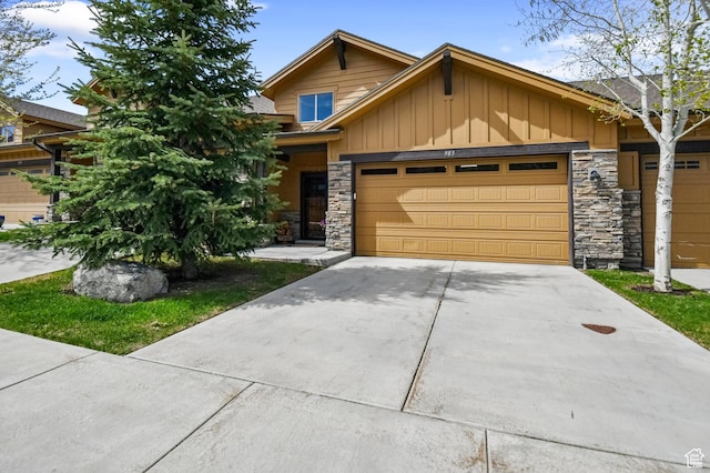 view of front of home with stone siding, board and batten siding, a garage, and concrete driveway