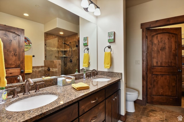 full bathroom with tiled shower, double vanity, toilet, and tile patterned floors