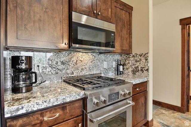 kitchen with appliances with stainless steel finishes, backsplash, and baseboards