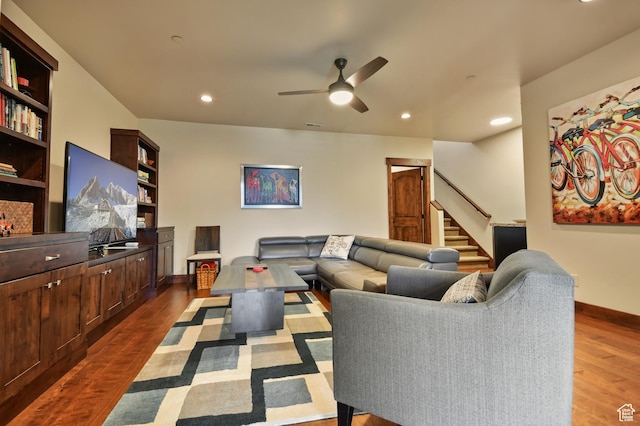 living room featuring dark wood-type flooring, stairway, baseboards, ceiling fan, and recessed lighting