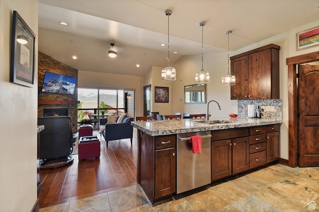 kitchen featuring stainless steel dishwasher, vaulted ceiling, a sink, open floor plan, and a peninsula