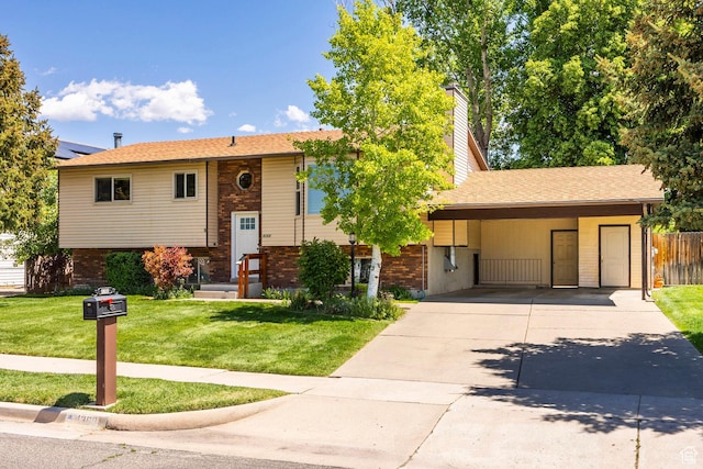 raised ranch with brick siding, concrete driveway, a front lawn, and a chimney