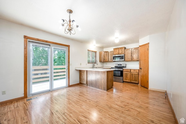 kitchen with stainless steel appliances, light wood-type flooring, a peninsula, and light countertops