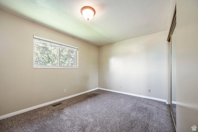 carpeted empty room featuring baseboards