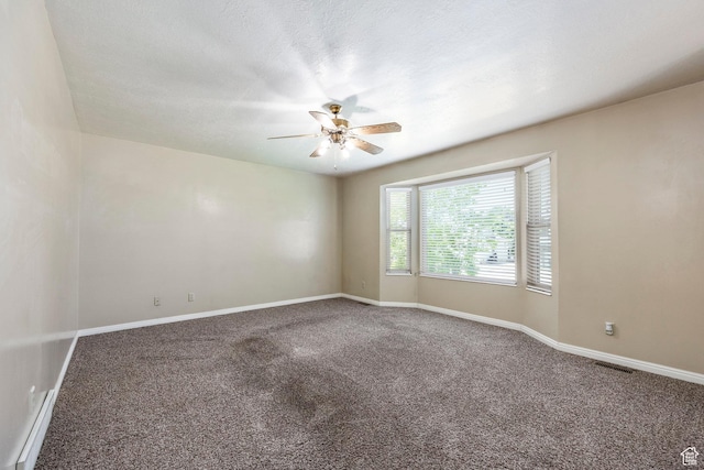 carpeted empty room with ceiling fan and baseboards