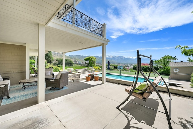 1274 E Chandler, Salt Lake City, UT 84103 - view of patio / terrace with a balcony, a mountain view, and an outdoor pool