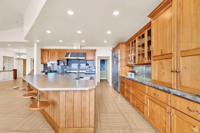 1274 E Chandler, Salt Lake City, UT 84103 - kitchen featuring built in refrigerator, decorative backsplash, wall chimney range hood, a sink, and a kitchen island with sink