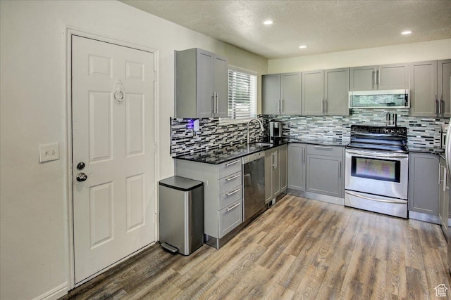 5812 Club View Ln, South Ogden, UT 84405 - kitchen featuring appliances with stainless steel finishes, gray cabinets, a textured ceiling, a sink, and wood finished floors