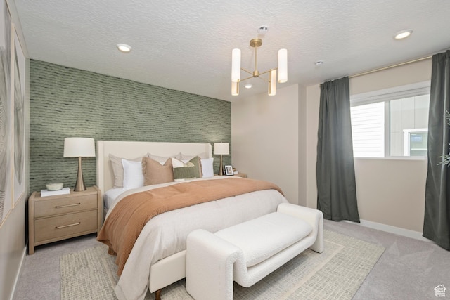 bedroom with baseboards, light carpet, recessed lighting, a chandelier, and an accent wall