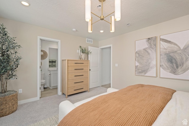 bedroom with light colored carpet, baseboards, recessed lighting, ensuite bathroom, and a textured ceiling