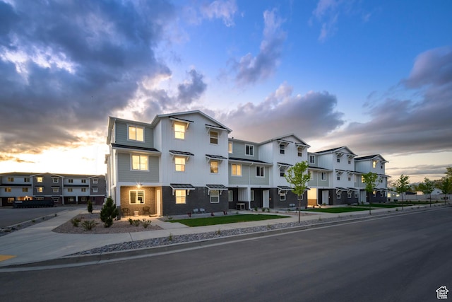 townhome / multi-family property featuring a residential view, board and batten siding, and brick siding