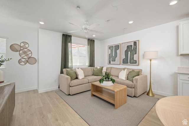 living area featuring ceiling fan, light wood-style floors, recessed lighting, and baseboards