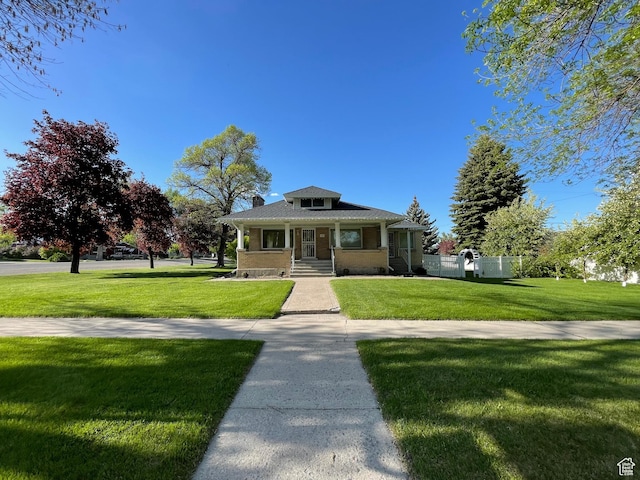 15 E Main, Wellsville, UT 84339 - bungalow-style house featuring covered porch, a front yard, a chimney, and brick siding
