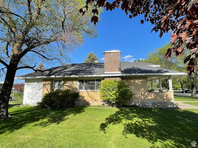 15 E Main, Wellsville, UT 84339 - rear view of house with brick siding, a lawn, and a chimney