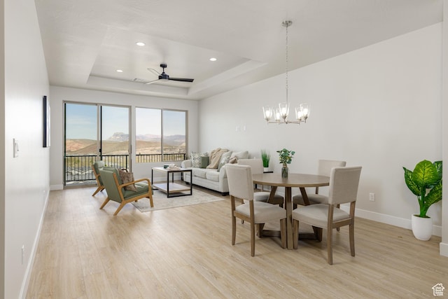 dining area with light wood-style flooring, a tray ceiling, baseboards, ceiling fan, and recessed lighting