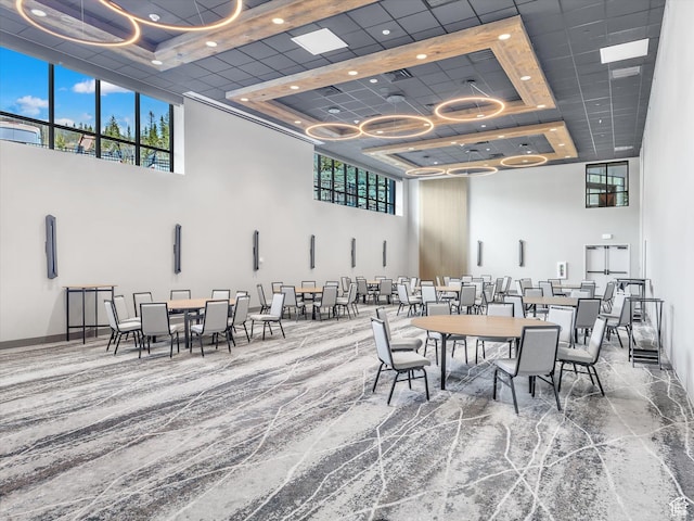 dining room with a high ceiling and a raised ceiling
