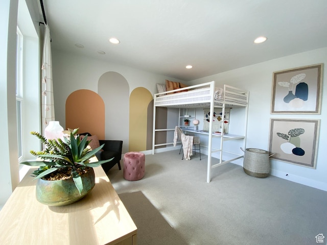 carpeted bedroom with recessed lighting and arched walkways