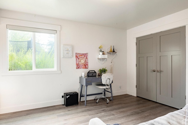 bedroom featuring light wood finished floors and baseboards