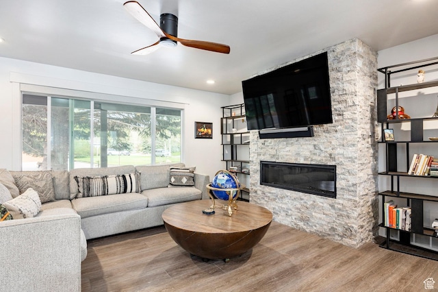 living room with ceiling fan, wood finished floors, and a fireplace