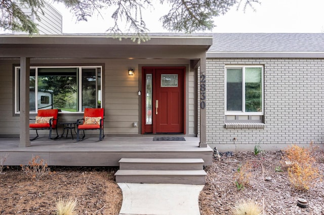 property entrance featuring brick siding and covered porch