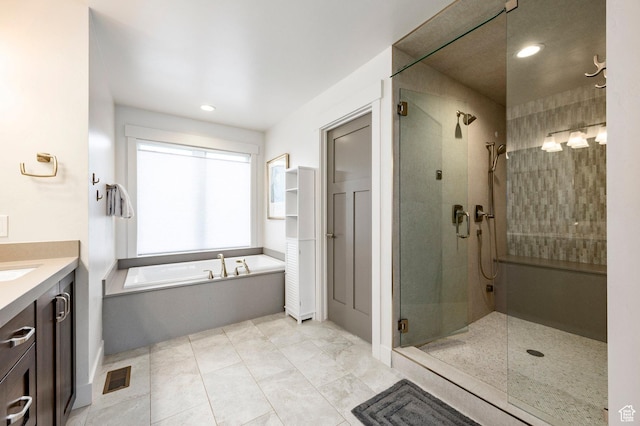 bathroom with a stall shower, a bath, vanity, and recessed lighting