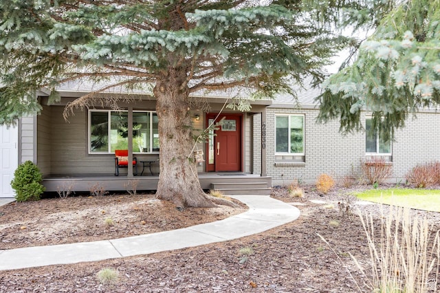 view of front of property with covered porch and brick siding