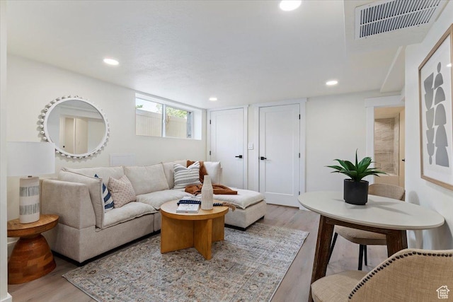 living room with light wood finished floors and recessed lighting