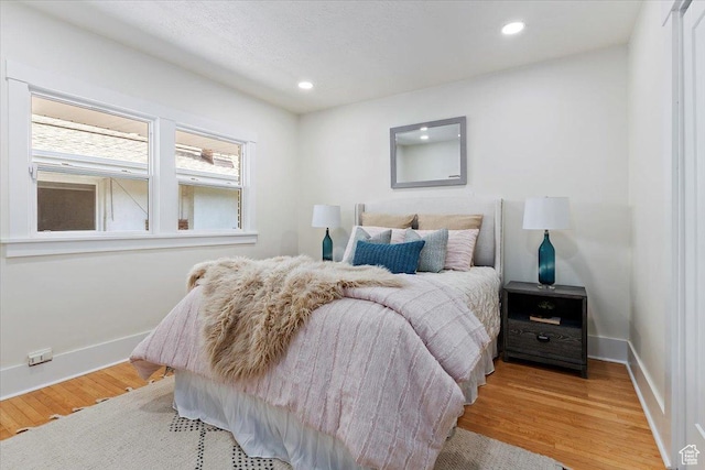 bedroom with light wood finished floors, recessed lighting, and baseboards