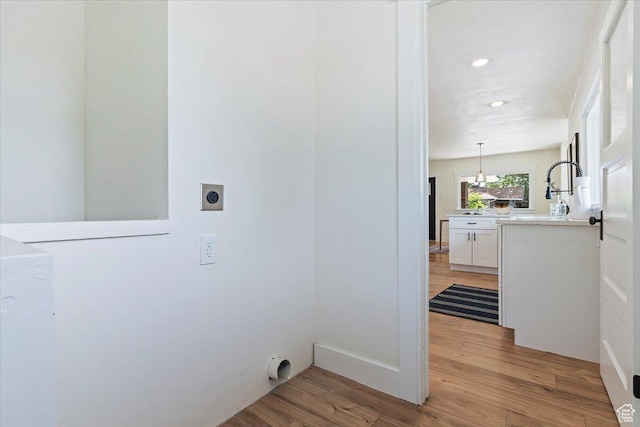 washroom featuring electric dryer hookup, light wood-style floors, and recessed lighting