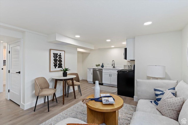 living room featuring light wood-type flooring, recessed lighting, baseboards, and bar with sink