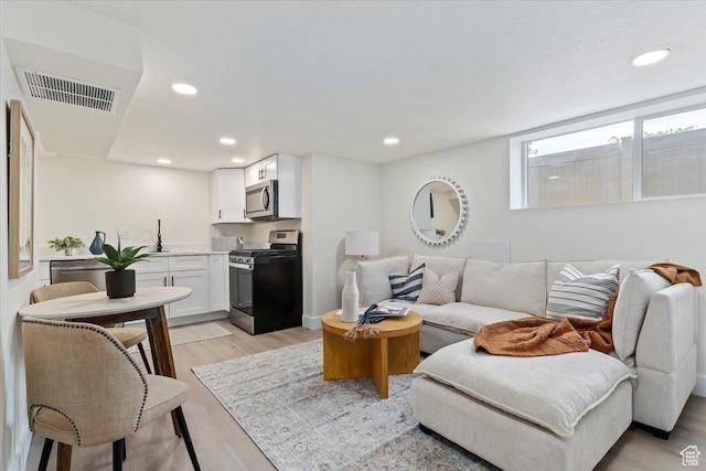 living area featuring light wood-style floors and recessed lighting