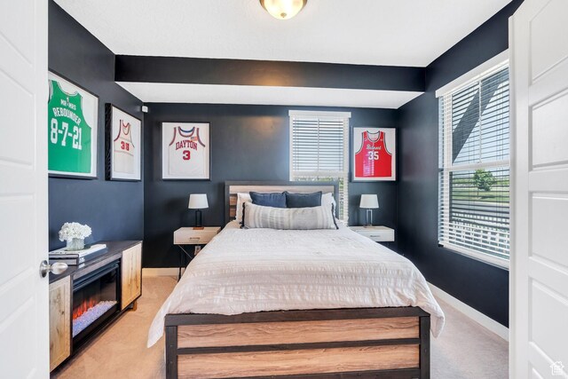 bedroom featuring light carpet and baseboards