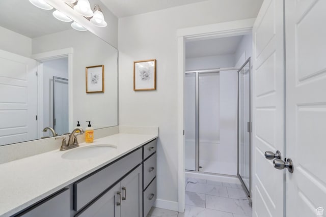 full bath featuring marble look tiles, baseboards, a shower stall, and vanity