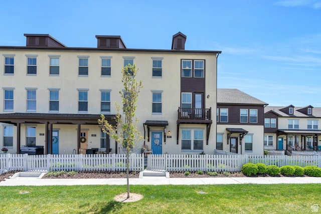 multi unit property with stucco siding and a fenced front yard