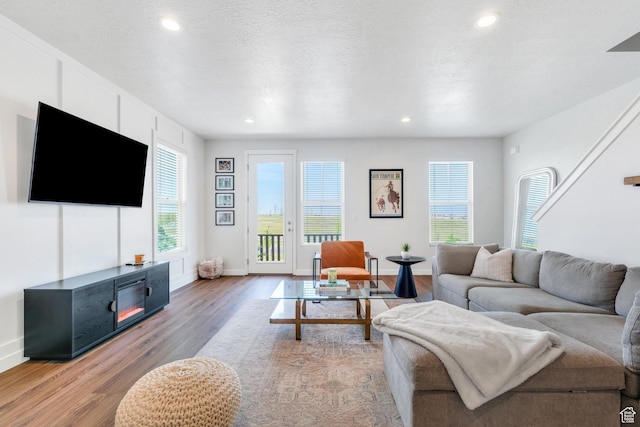living room featuring light wood finished floors, recessed lighting, and baseboards