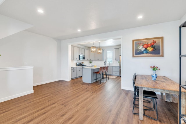 dining space with light wood-style floors, baseboards, and recessed lighting