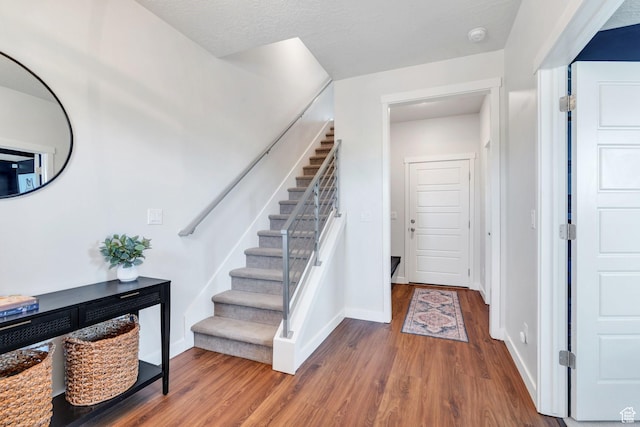 stairs featuring wood finished floors and baseboards