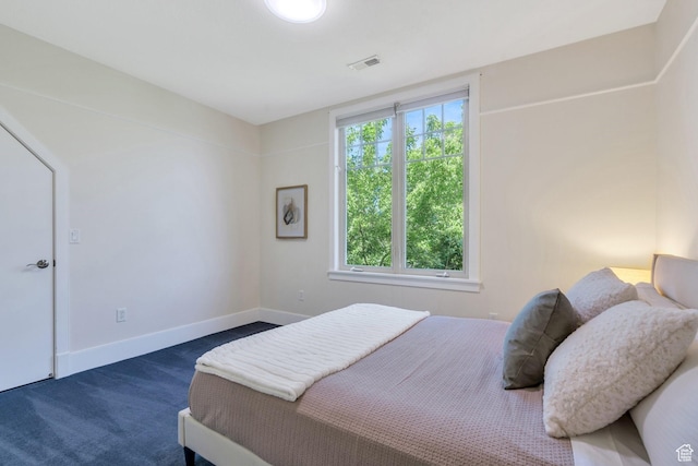 bedroom featuring dark carpet and baseboards