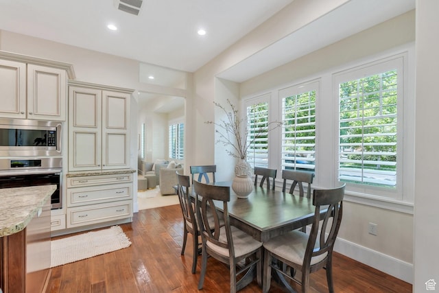 dining space with dark wood-type flooring, recessed lighting, and baseboards