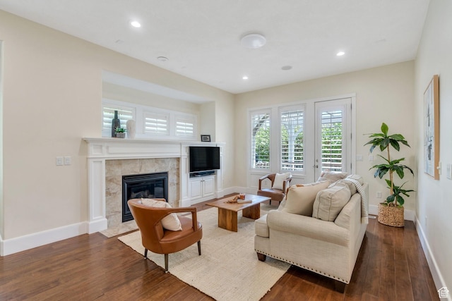 living room with dark wood-type flooring, baseboards, a fireplace, and recessed lighting