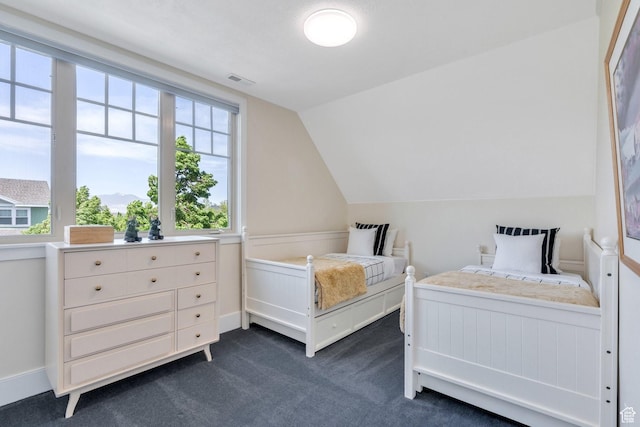 bedroom featuring dark carpet and lofted ceiling
