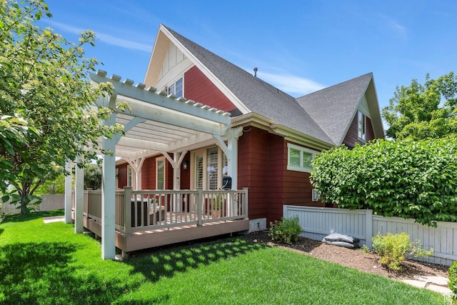 back of house with a pergola, a deck, and roof with shingles