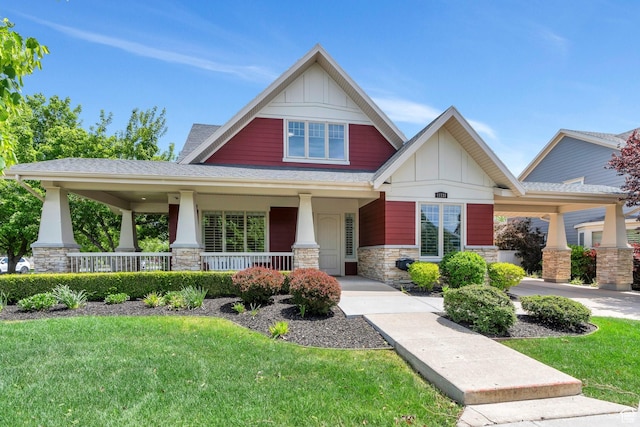 craftsman house with board and batten siding, stone siding, a porch, and a front yard