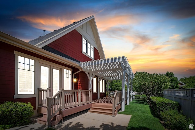 rear view of property featuring a pergola and fence