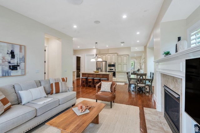 living area featuring light wood-style flooring, recessed lighting, and a fireplace