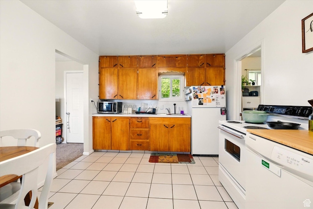 1317 S 400 E, Trenton, UT 84338 - kitchen with white appliances, brown cabinetry, light countertops, and a sink