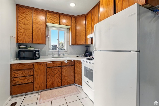 1317 S 400 E, Trenton, UT 84338 - kitchen featuring white appliances, a sink, brown cabinetry, light countertops, and under cabinet range hood